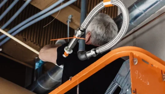 Interiör av lokal med rörinstallationer i taket.