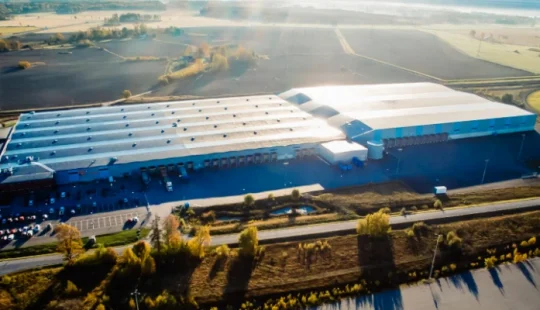 Översiktsvy av lagerbyggnad i landskap.