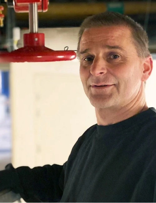 Servicemontör som arbetar med sprinklerinstallation i teknisk innermiljö.