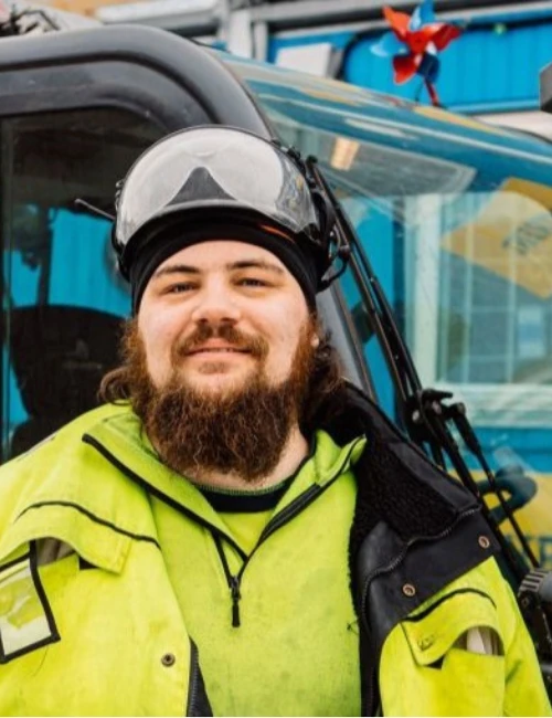 Sprinklermontör i arbetskläder och skyddsutrustning på byggarbetsplats.