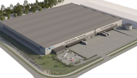 Exteriör av en lagerbyggnad med lastzon och grönytor.