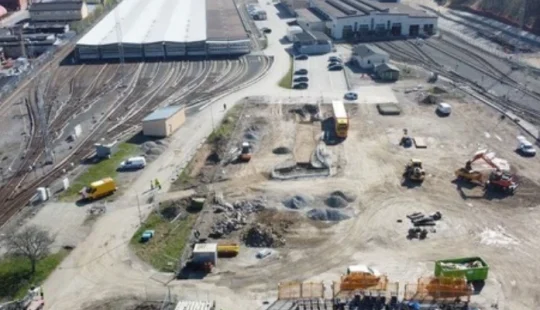 Översiktsvy av depåområde med byggnader och spår i Stockholm.