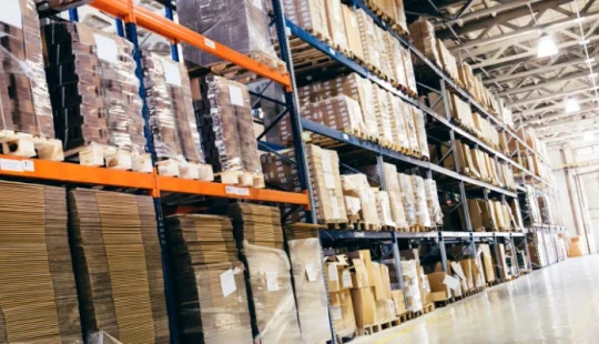 Interiör av lagerlokal med hyllsystem och kartonger.
