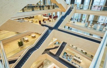 Interiörvy av kontorsbyggnad med ljusinsläpp och öppna ytor.