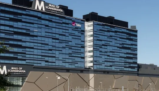 Interiörvy av köpcentrum med flera våningsplan och butiksytor.